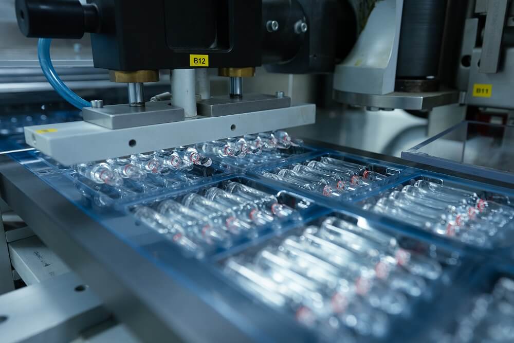 ampoule injection packing machine. glass ampoule vial making process with fire using fire in a pharmaceutical production factory. glass vials for medicine in a healthcare manufacturing facility. medic